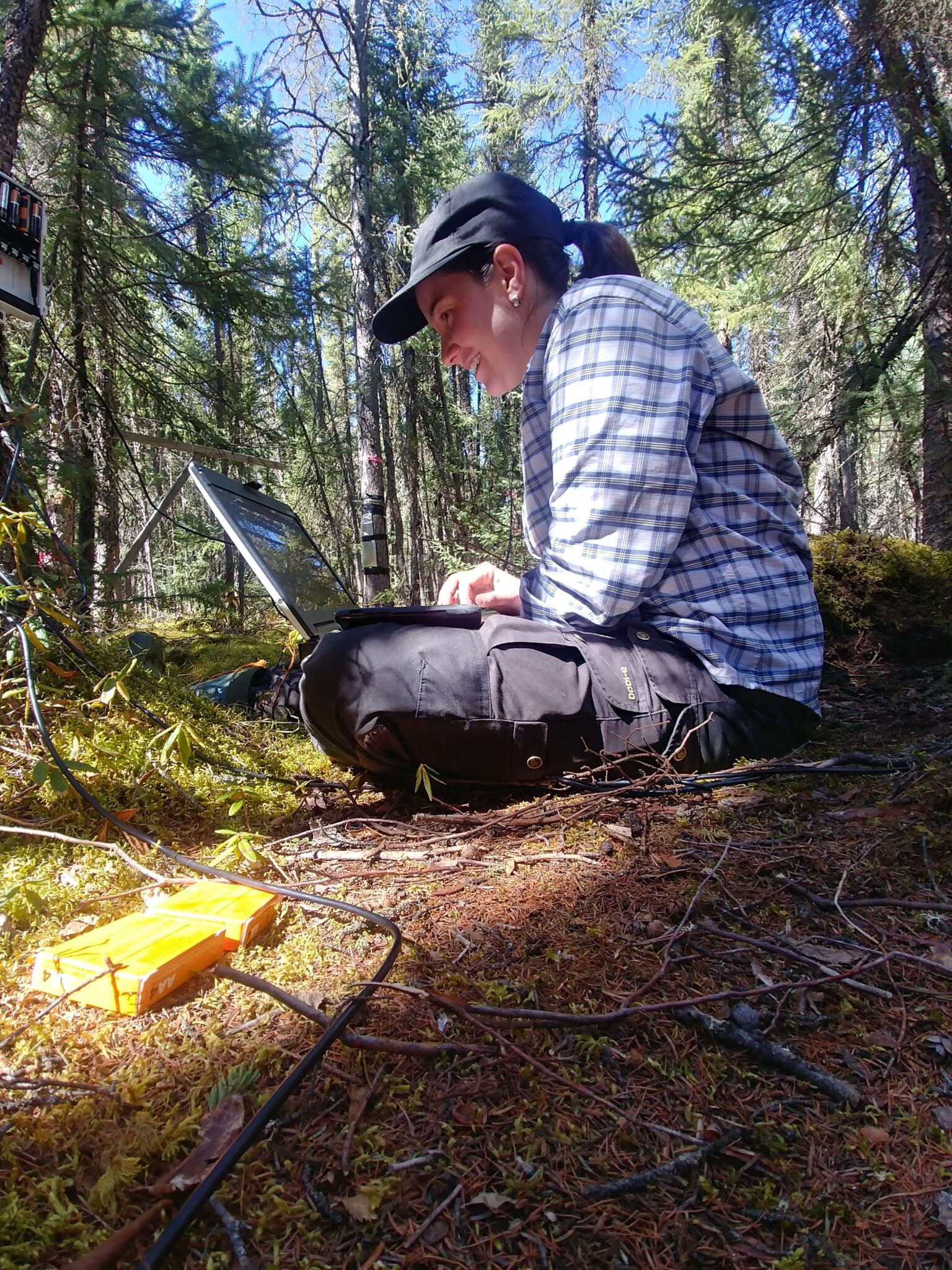 Nia uses her computer in the field